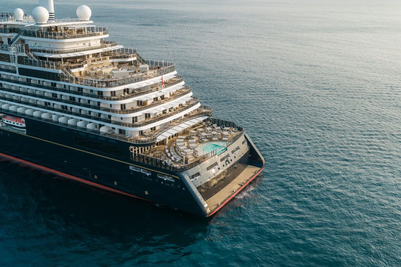 Explora III from the air, her terraced stern decks and pools stepping down toward deep blue open water