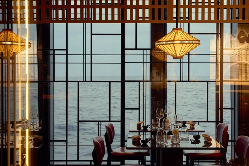 The Sakura restaurant on board, low lit with pale wood and a long sushi counter