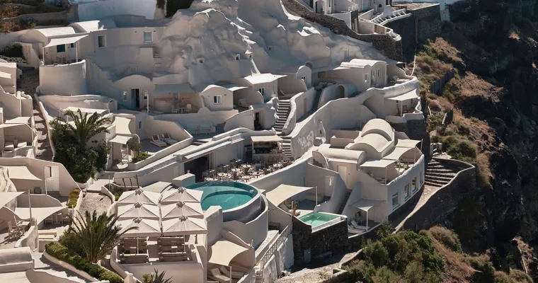 Whitewashed cave suites carved into the cliff at Mystique in Oia, Santorini