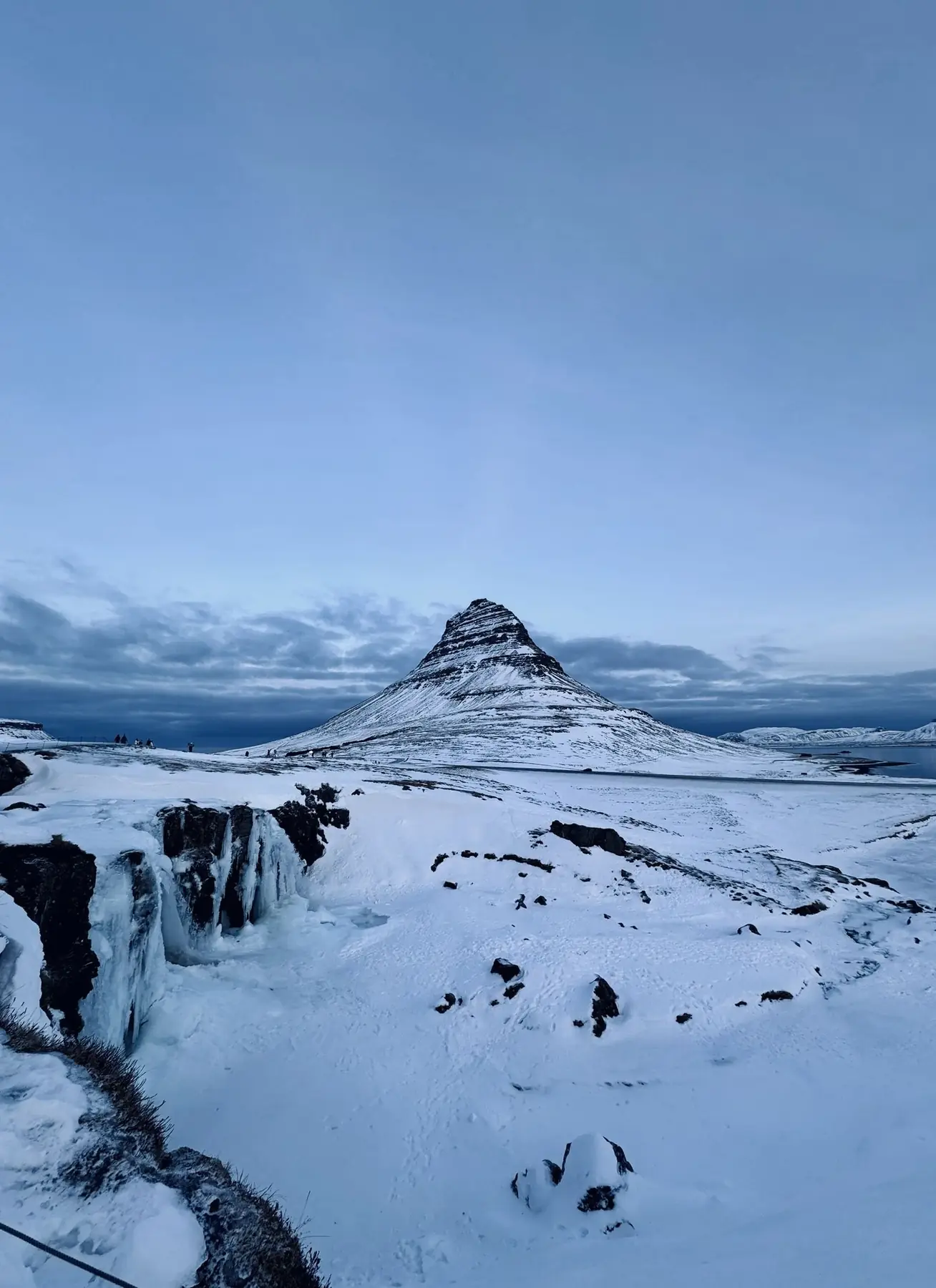 Kirkjufell mountain and its waterfall under winter snow