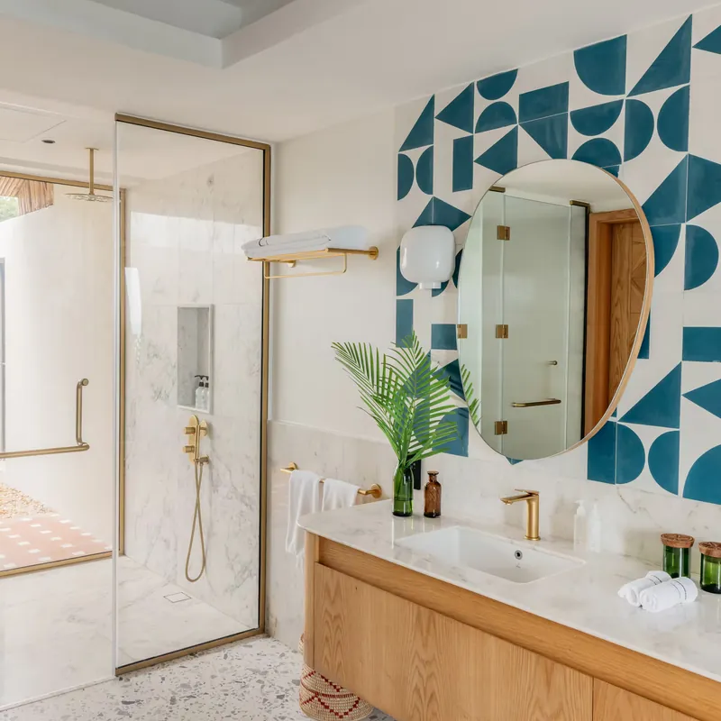 The villa bathroom with a glass walk-in shower and blue and white tiles