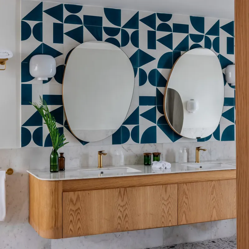 Double vanity with brass taps and patterned blue tiles in the villa bathroom