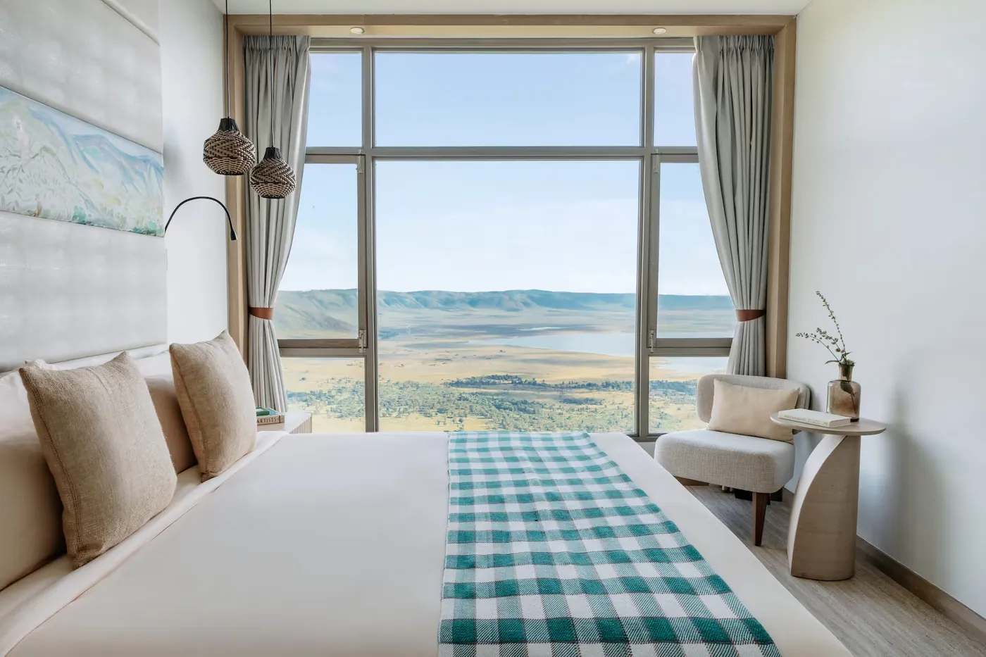 A Rim Room bed facing a floor to ceiling window over the Ngorongoro Crater