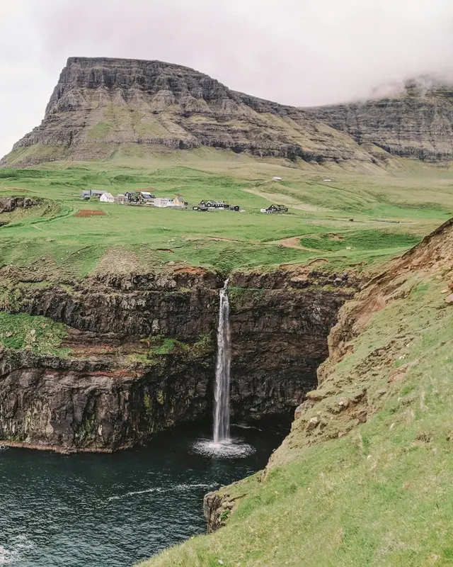Mulafossur waterfall dropping into the sea in the Faroe Islands