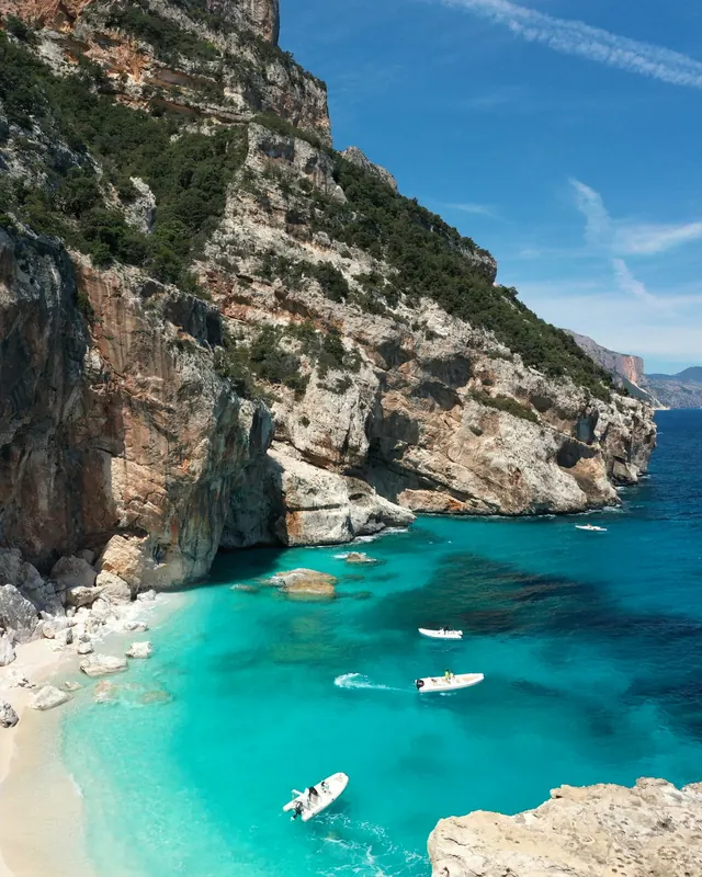 A turquoise cove below limestone cliffs in Sardinia